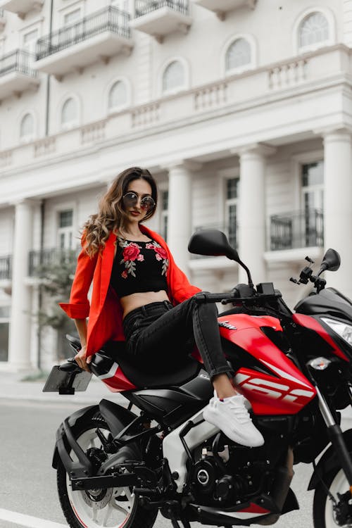 Woman in Red Suit Jacket on Motorbike