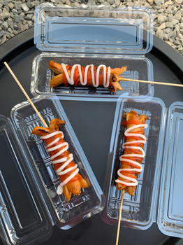 Tasty skewered sausages drizzled with ketchup and mayonnaise, perfect for foodies.