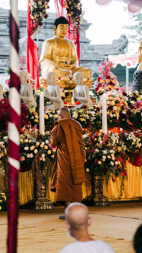 Buddhist monk praying in front of buddha statue during vesak day