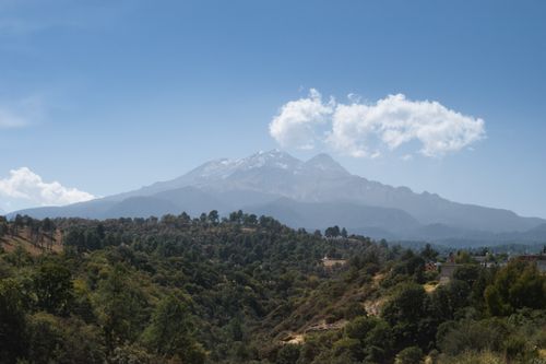 Free Breathtaking view of Mount Iztaccihuatl from Amecameca, featuring lush forests and clear skies. Stock Photo