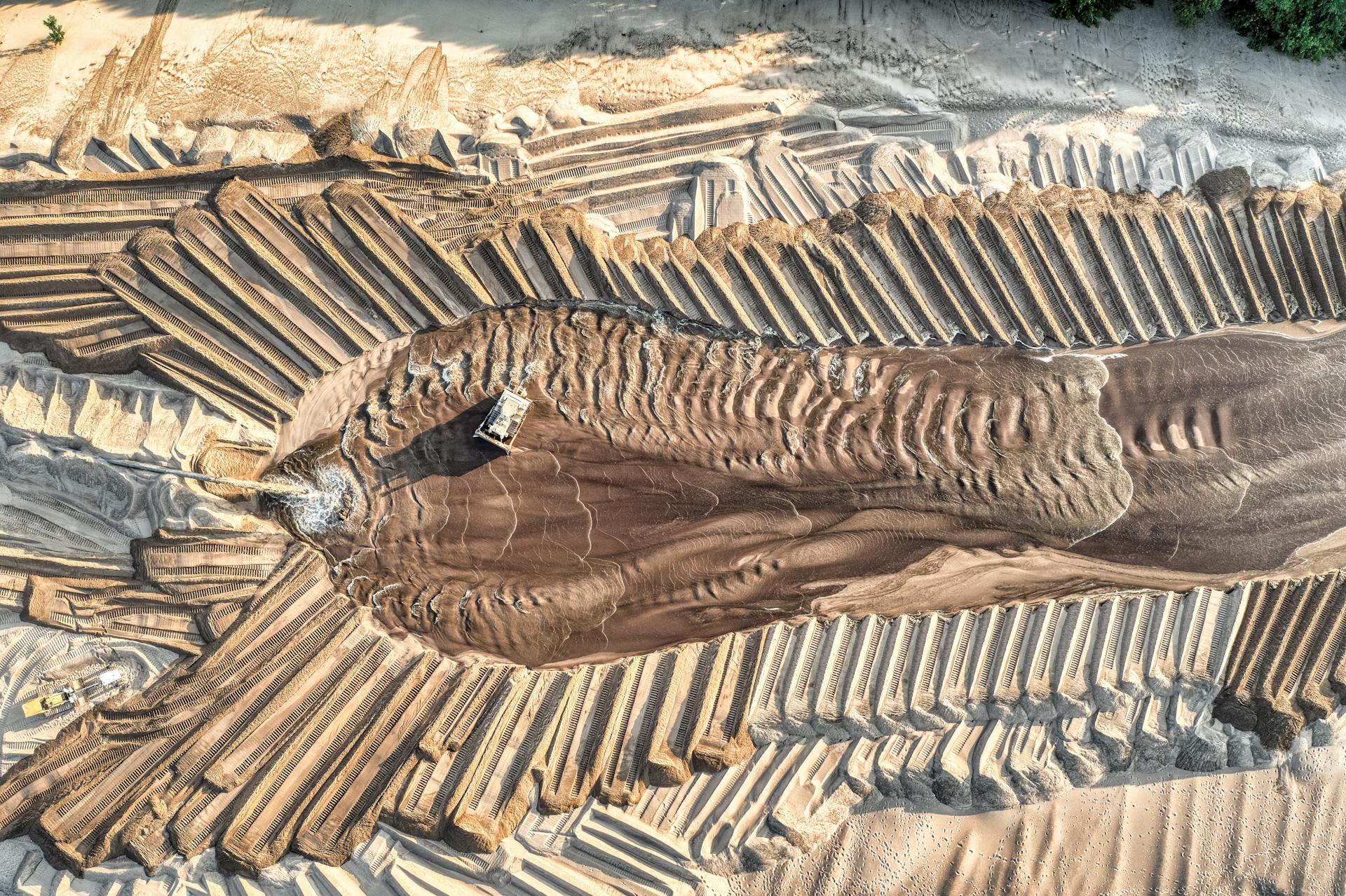 Aerial view of sand mining operations with machinery and patterned landscape in Reads Landing, MN.