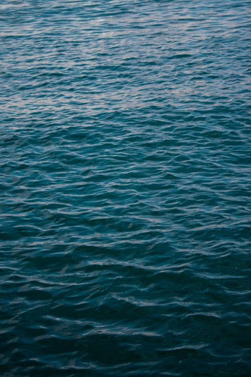 Free Peaceful ocean waves capturing the serene beauty of nature's tranquil waters at sunset. Stock Photo