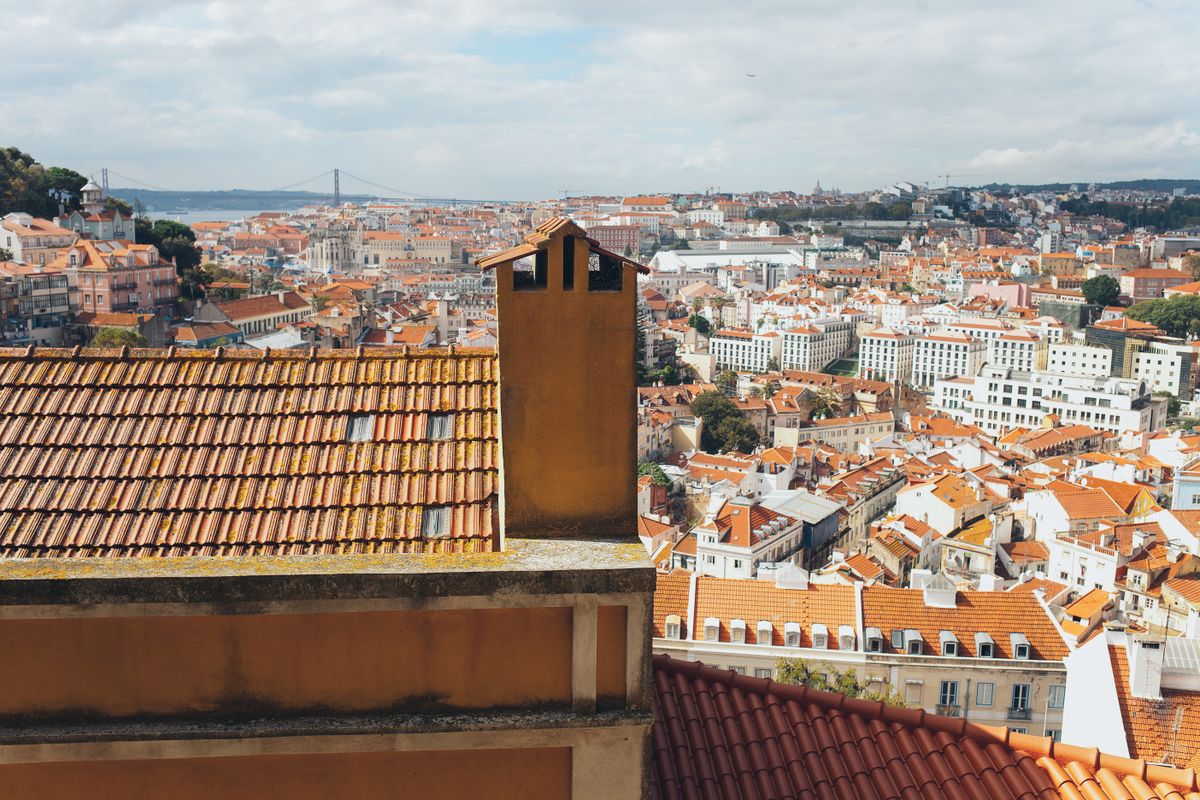 Red-tiled rooftops of Lisbon sloping down toward the river — photo by Elina Sazonova on Pexels