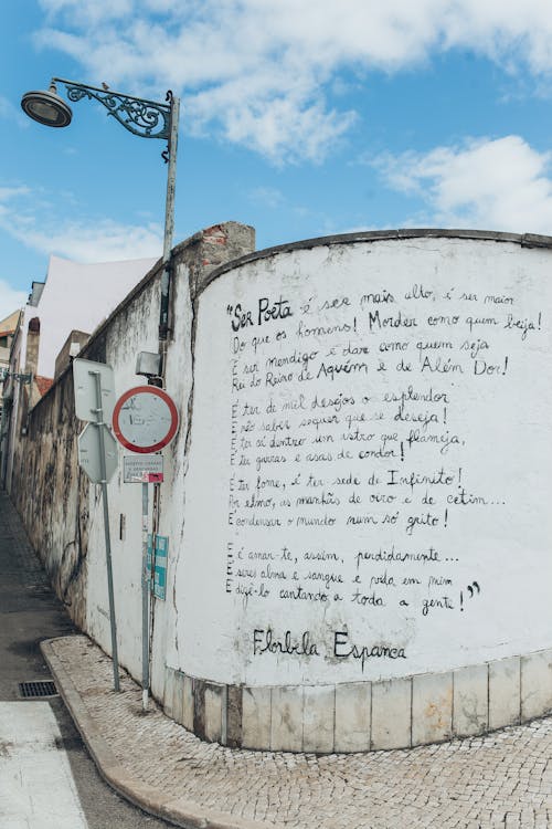 White Wall With Black Text Beside Street Lamp