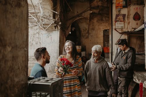 Free A couple sharing roses and laughter in the streets of Vadodara, India. Stock Photo
