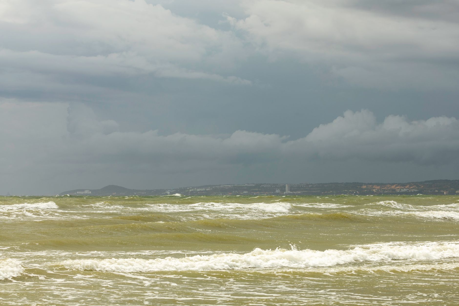 A captivating view of the ocean under a stormy sky. Turbulent waves and dark clouds create a dramatic seascape.