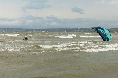 Free A kite surfer mastering waves on a windy ocean day, embodying thrill and skill. Stock Photo