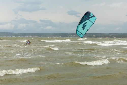Free Experience thrilling kiteboarding action on the open sea with dynamic waves and sky. Stock Photo