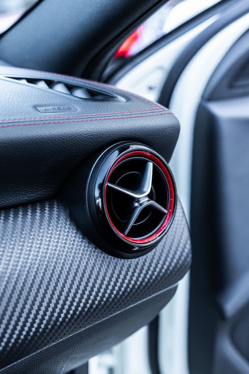 Free Close-up of a modern car dashboard vent with carbon fiber trim. Stock Photo