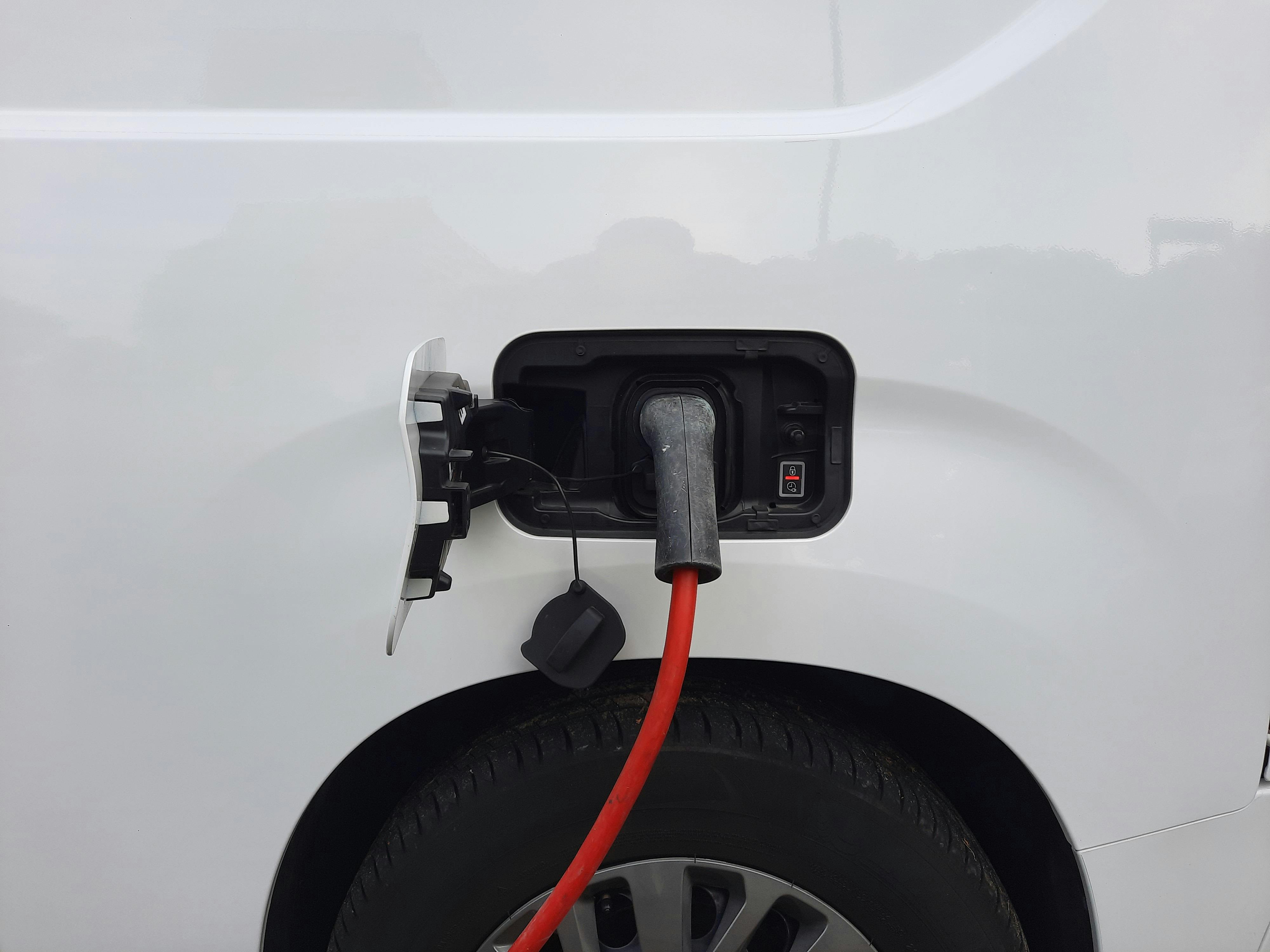 Close-up view of an electric vehicle charging port with a connected charging cable.