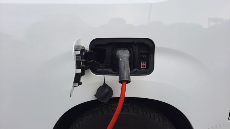 Electric car charging cable connected to a wall box mounted in a home garage