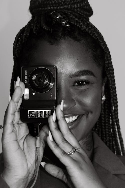 Smiling Woman Taking Pictures with Camera in Black and White