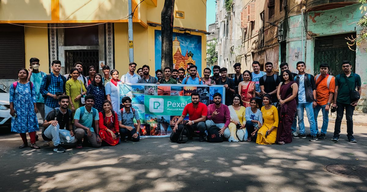 A lively group photo taken on a vibrant street in Kolkata, capturing local architecture.