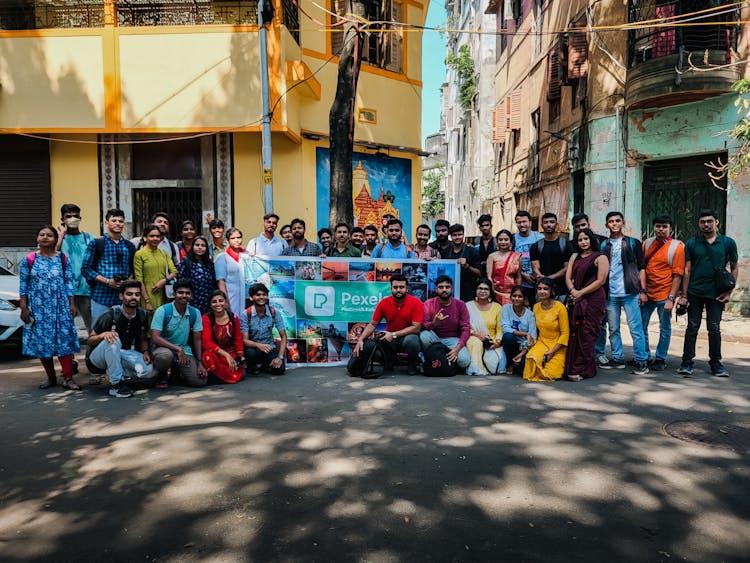 Group Of Tourists With Pexels Banner