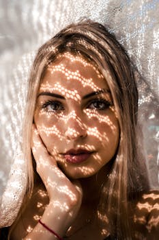 特写镜头中，一位女性脸上映着错综复杂的蕾丝阴影，构成了一幅戏剧性的肖像