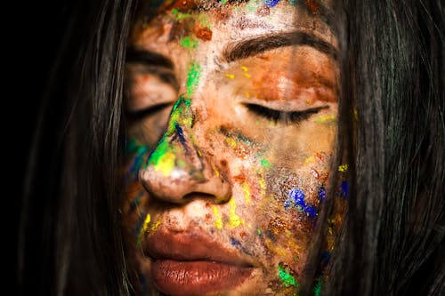女人的臉上塗著顏料的特寫照片