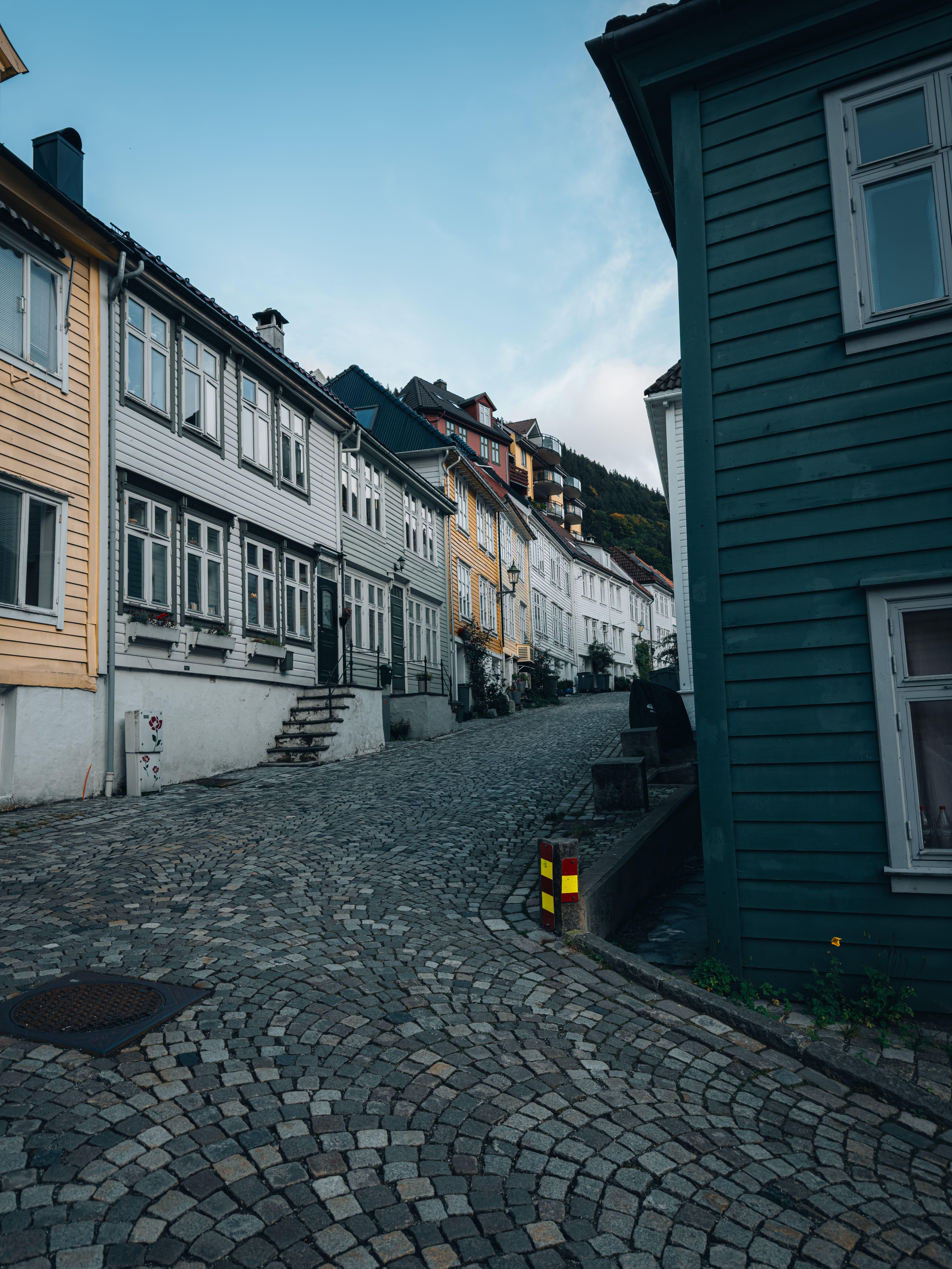 Charming cobblestone street lined with colorful historic houses on an uphill slope.