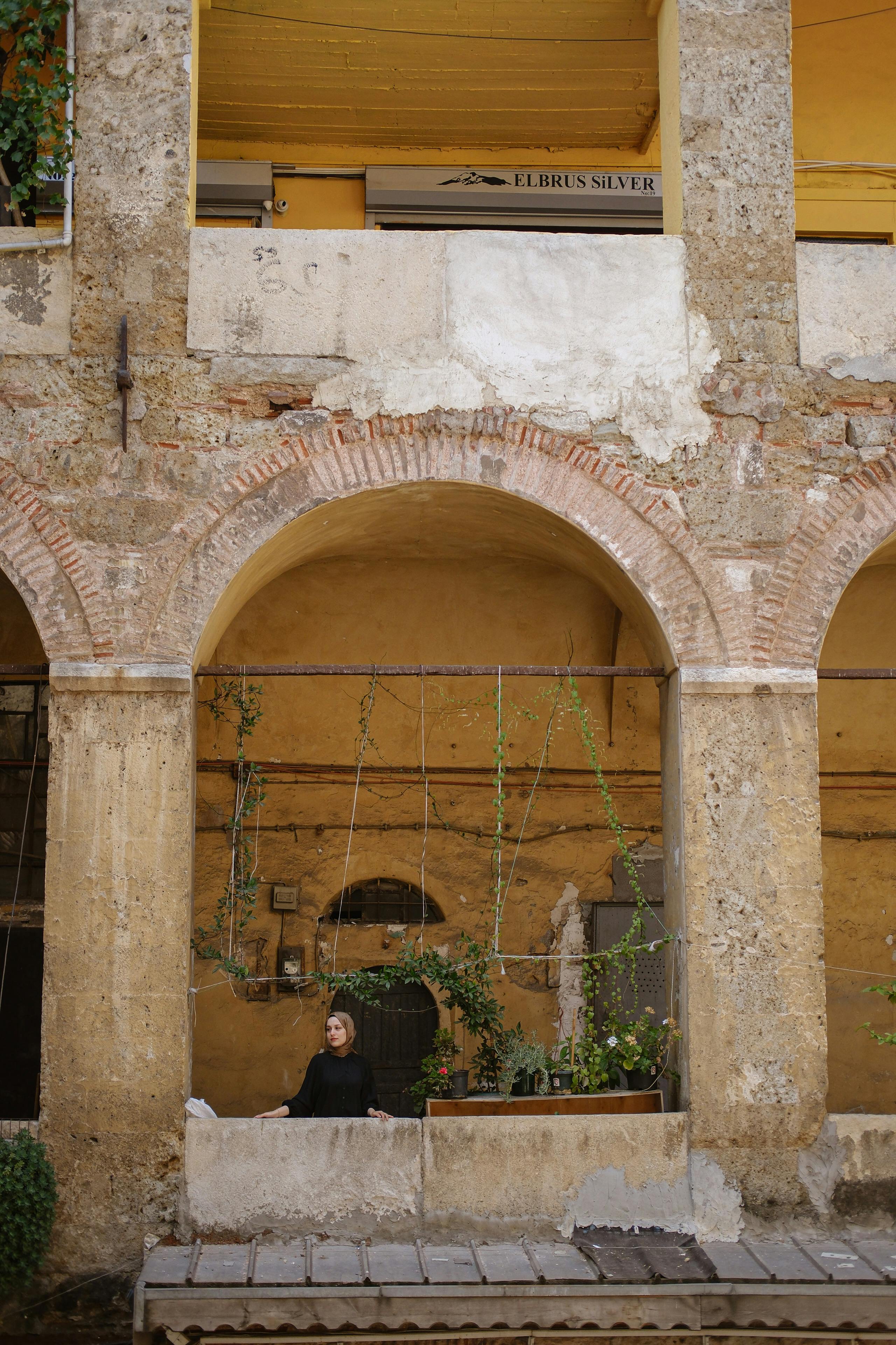 a woman sitting on a bench in an old building