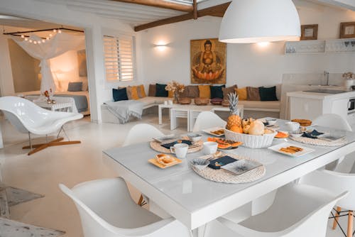 A white dining room with a table and chairs