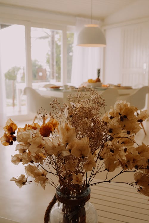 A vase filled with dried flowers sitting on a table