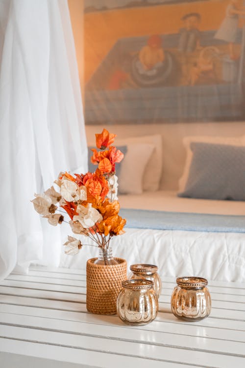 A bed with a white sheet and orange flowers