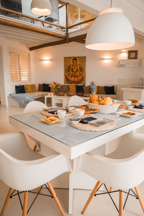 A white table with chairs and a white couch