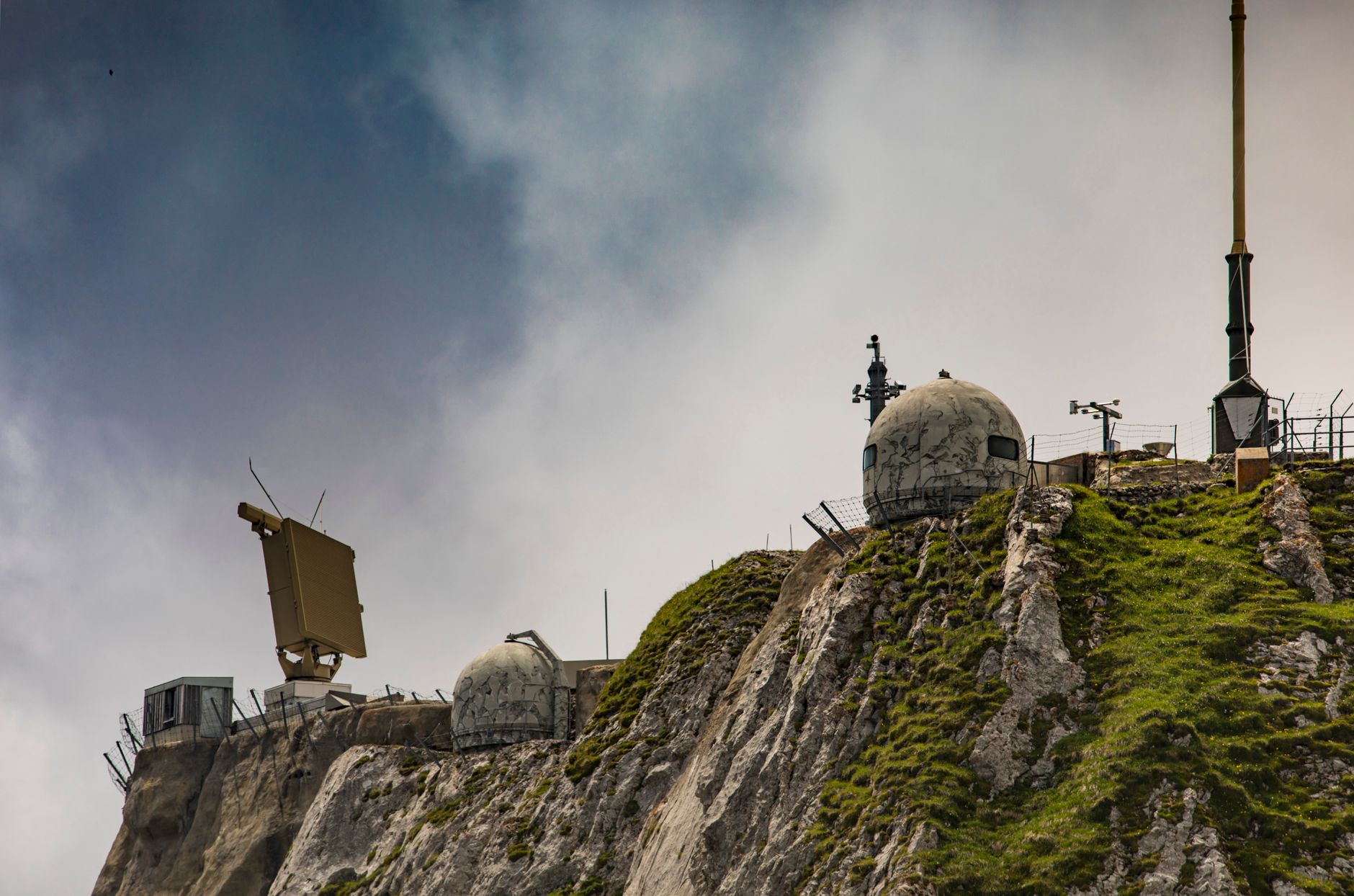 Swiss radar system perched on a rugged mountainside, showcasing technical and natural contrast.