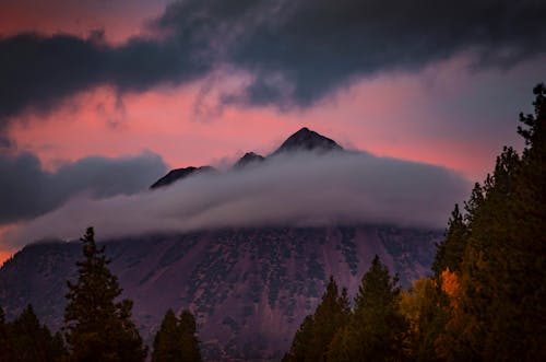View of Mountains Covered in Clouds at Sunset