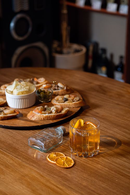 Free A cozy indoor setup featuring whiskey with orange slices, snacks, and a comfortable ambiance. Stock Photo