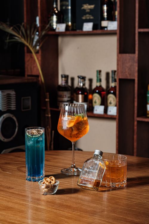 Free An elegant assortment of cocktails displayed on a rustic bar table in a cozy setting. Stock Photo