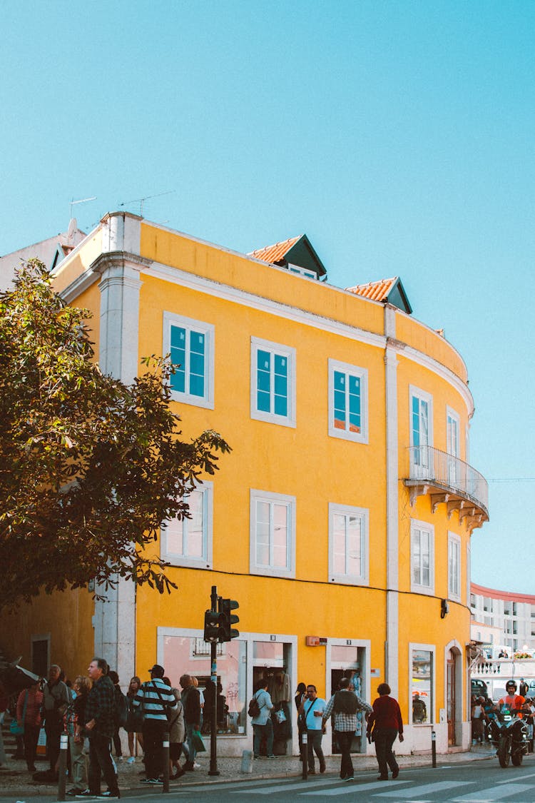 People Walking Beside Yellow Building