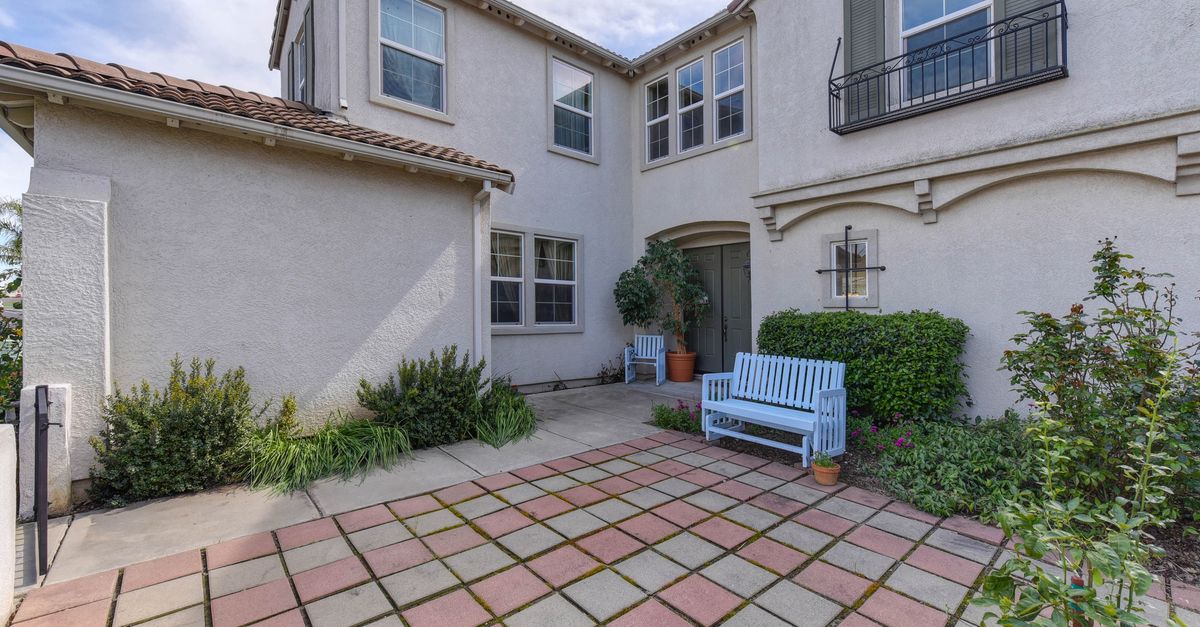 Elegant suburban home with a cozy patio area and vibrant garden.