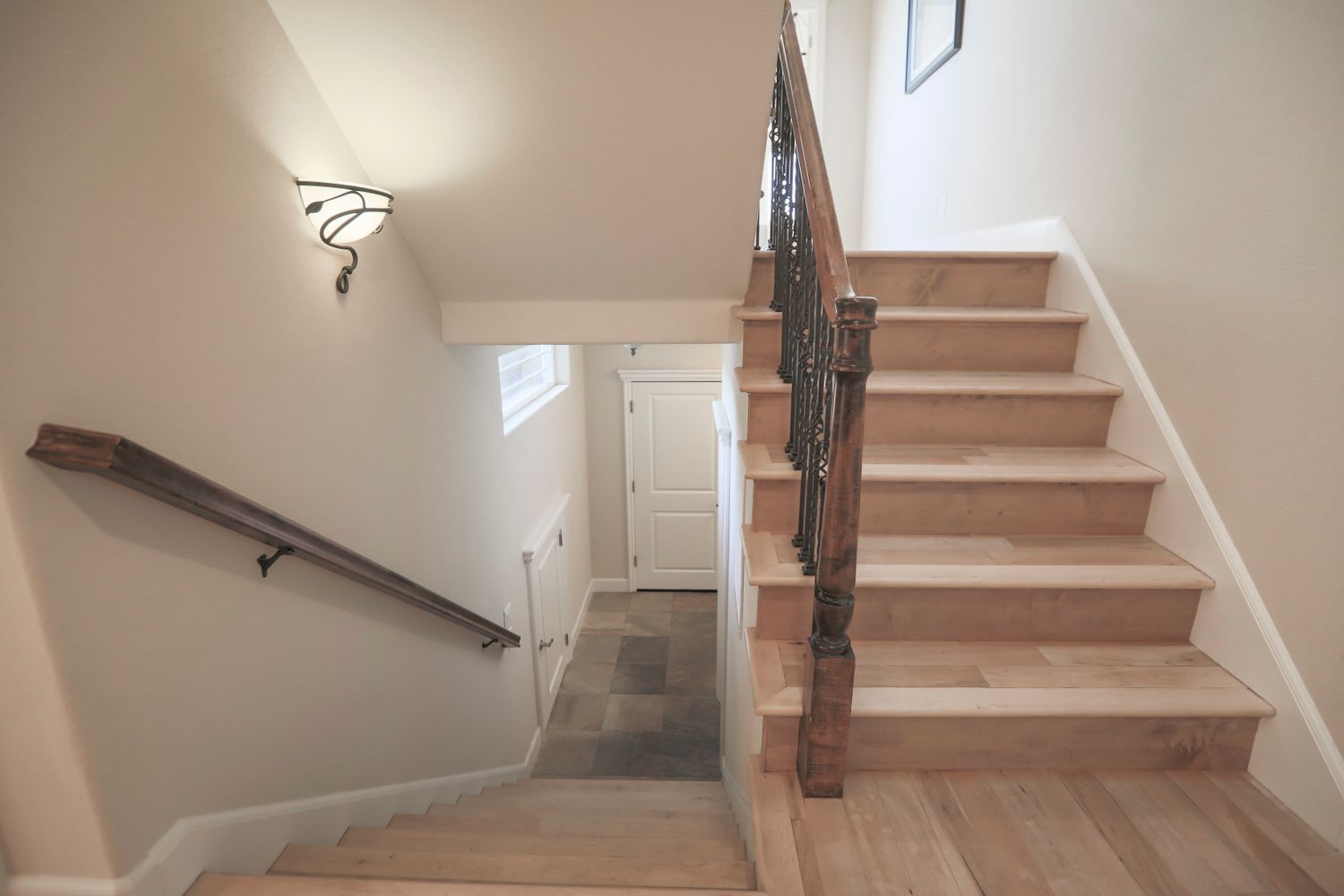 A wooden staircase with an artistic railing in a modern home interior