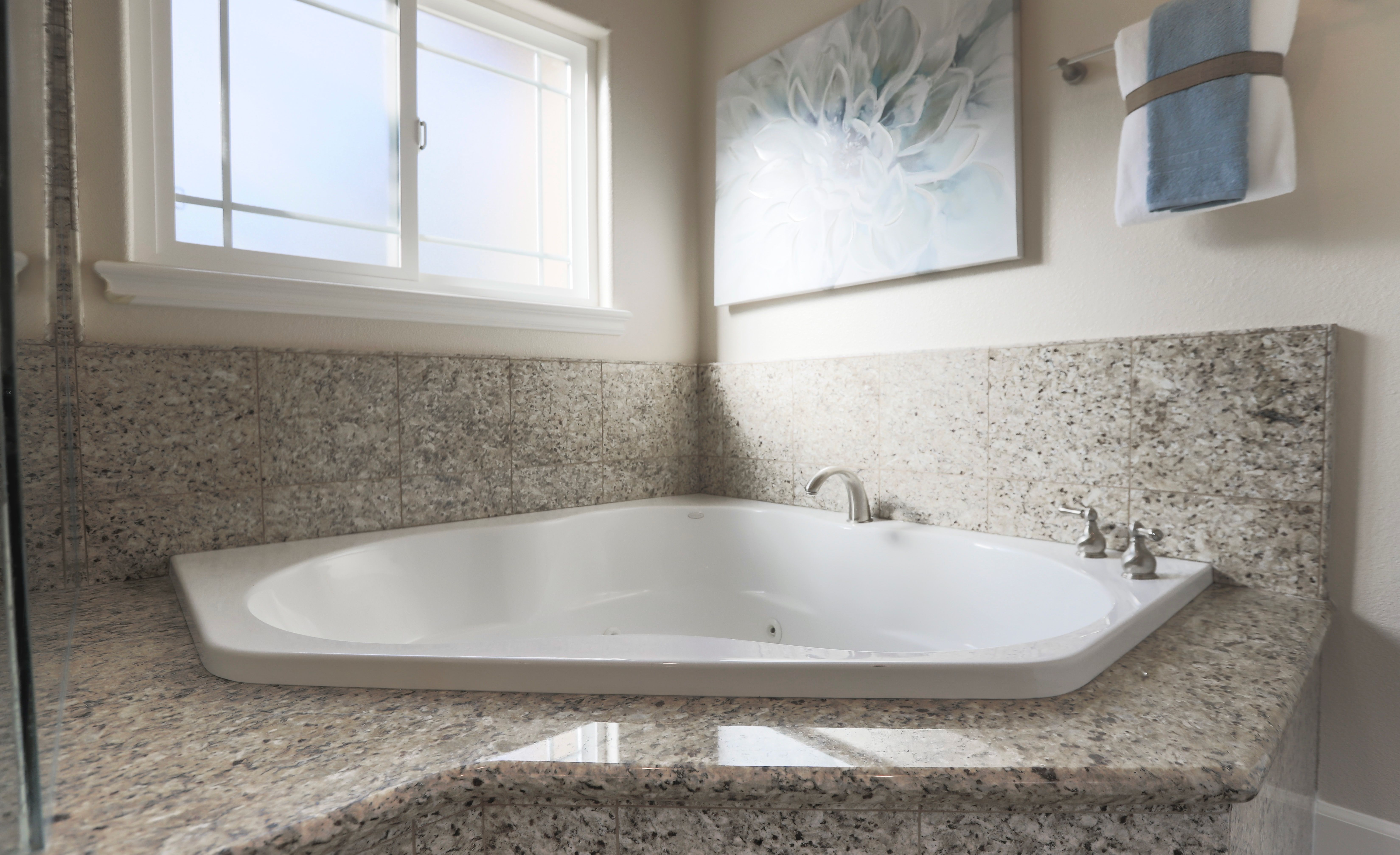 Large empty white bathtub in a bright bathroom, ready to be filled for a laundry strip soak