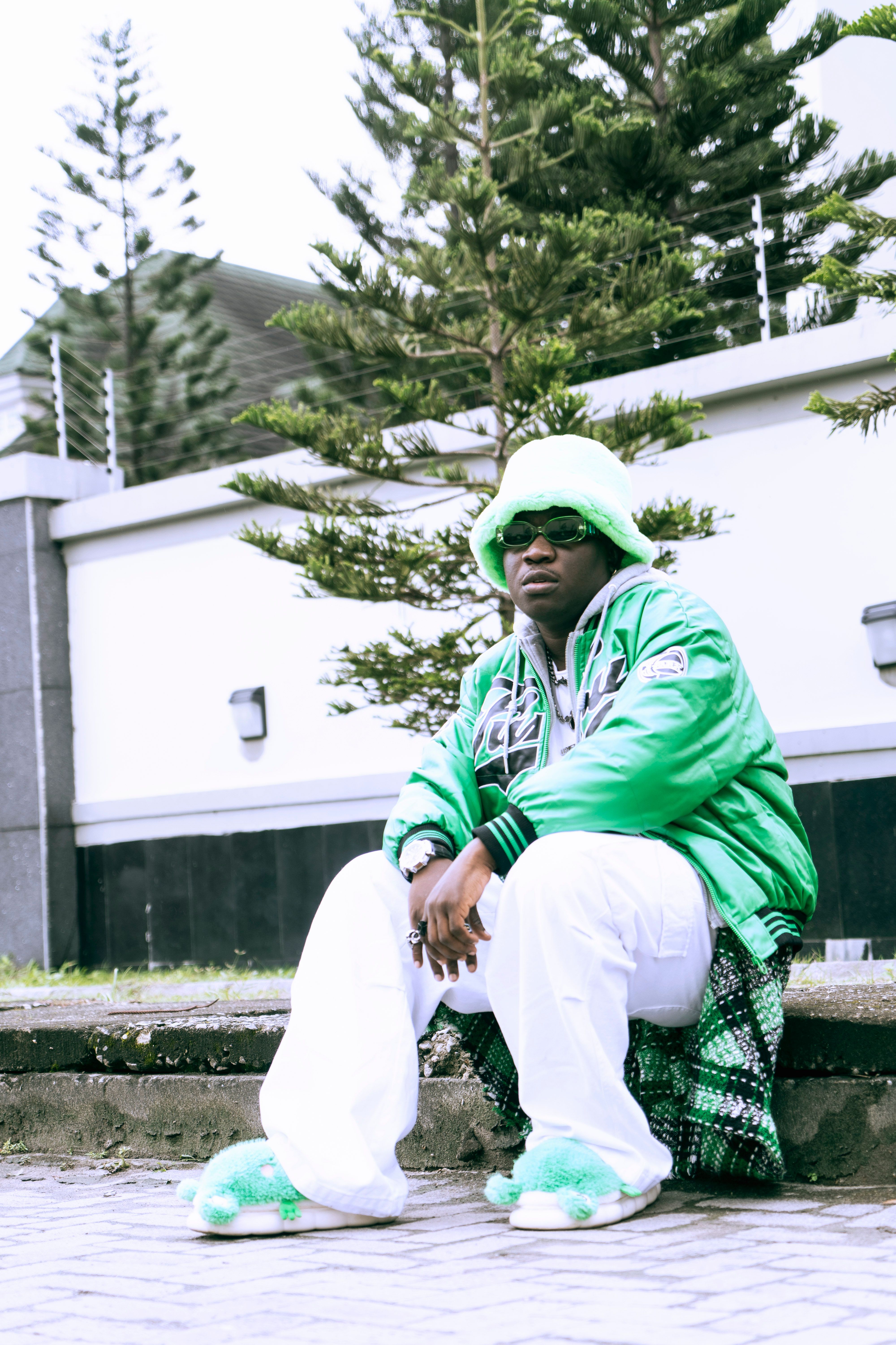a man in green and white sitting on a bench