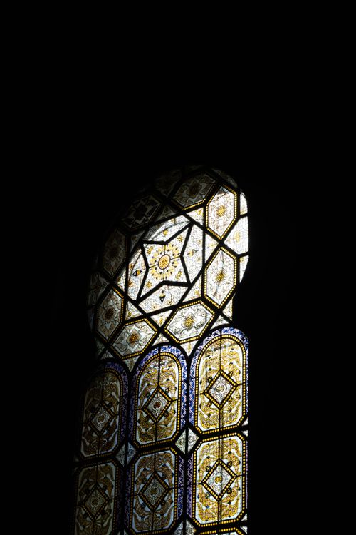 Free A beautifully crafted stained glass window in a dark church interior. Stock Photo