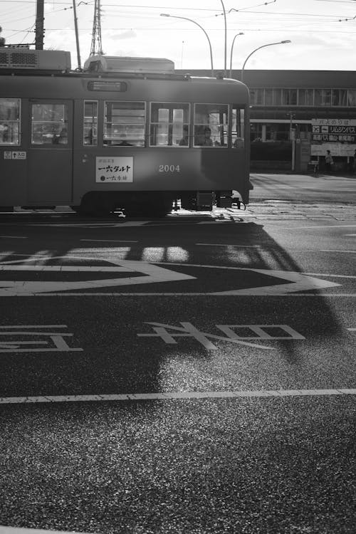 Black and White Photo of a Street and Tram