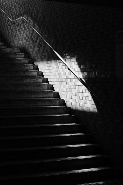 Free Black and white photo of stairs with dramatic lighting and shadows, creating a moody effect. Stock Photo