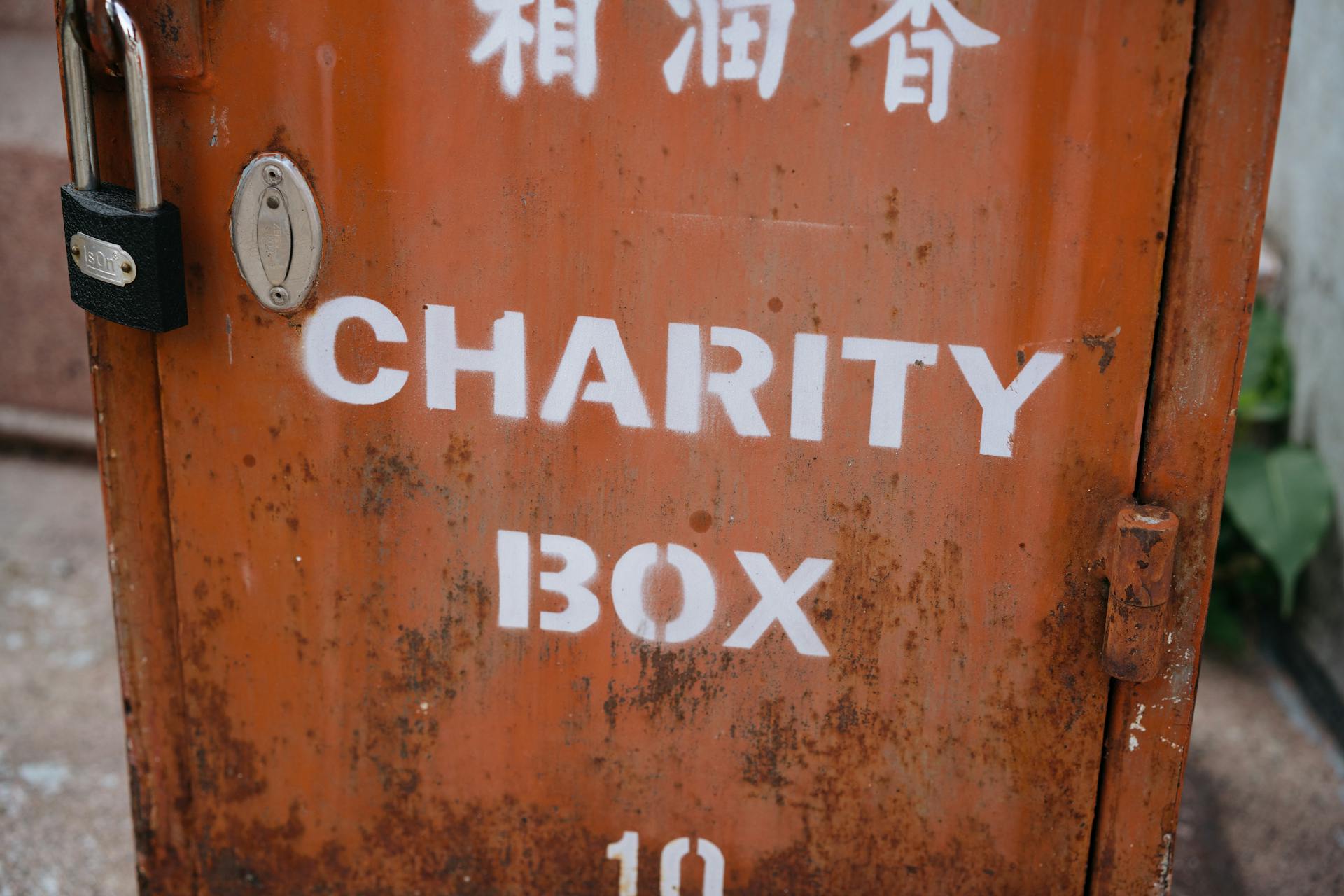 A weathered charity box with a padlock, symbolizing public contribution and community aid.