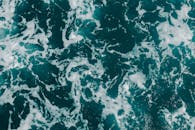 这张动态航拍照片捕捉了具有泡沫纹理的海浪，展现了海洋的图案