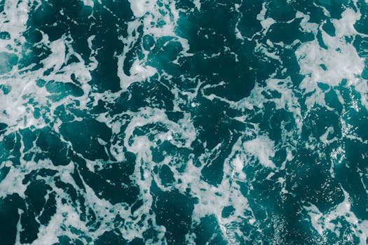 这张动态航拍照片捕捉了具有泡沫纹理的海浪，展现了海洋的图案