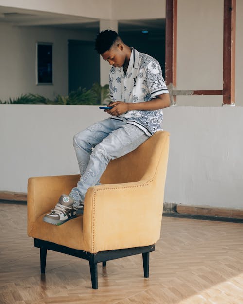A man sitting on a chair with his phone