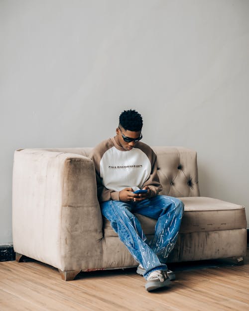 A man sitting on a couch looking at his phone
