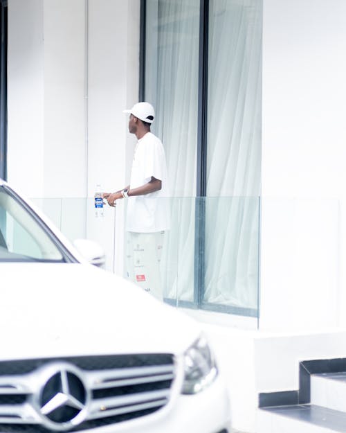 A man standing in front of a white mercedes