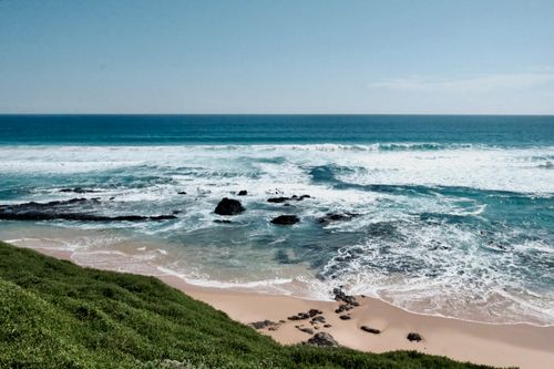 Free A tranquil beach scene with rolling waves and a sandy shore, perfect for nature lovers. Stock Photo