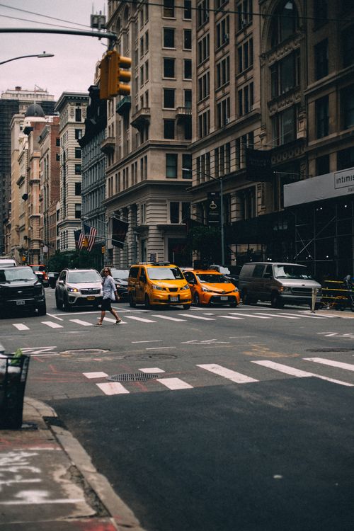 Free Urban scene featuring traffic and pedestrians in New York City with iconic yellow cabs. Stock Photo