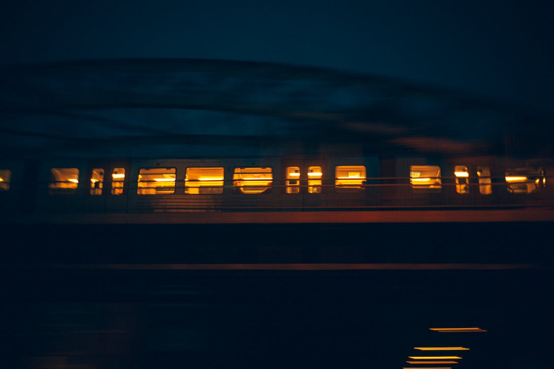 Illuminated Train on a Bridge at Night