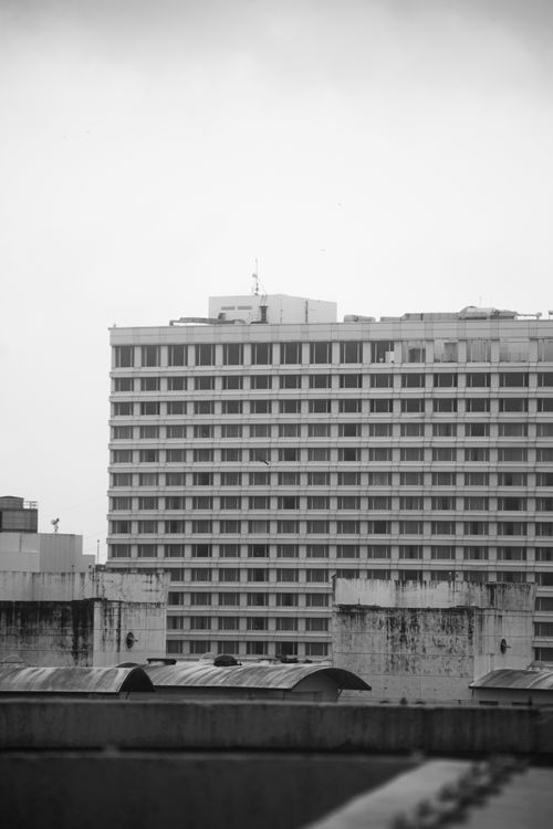 Free Monochrome image of a tall urban apartment building with multiple windows. Ideal for cityscape themes. Stock Photo