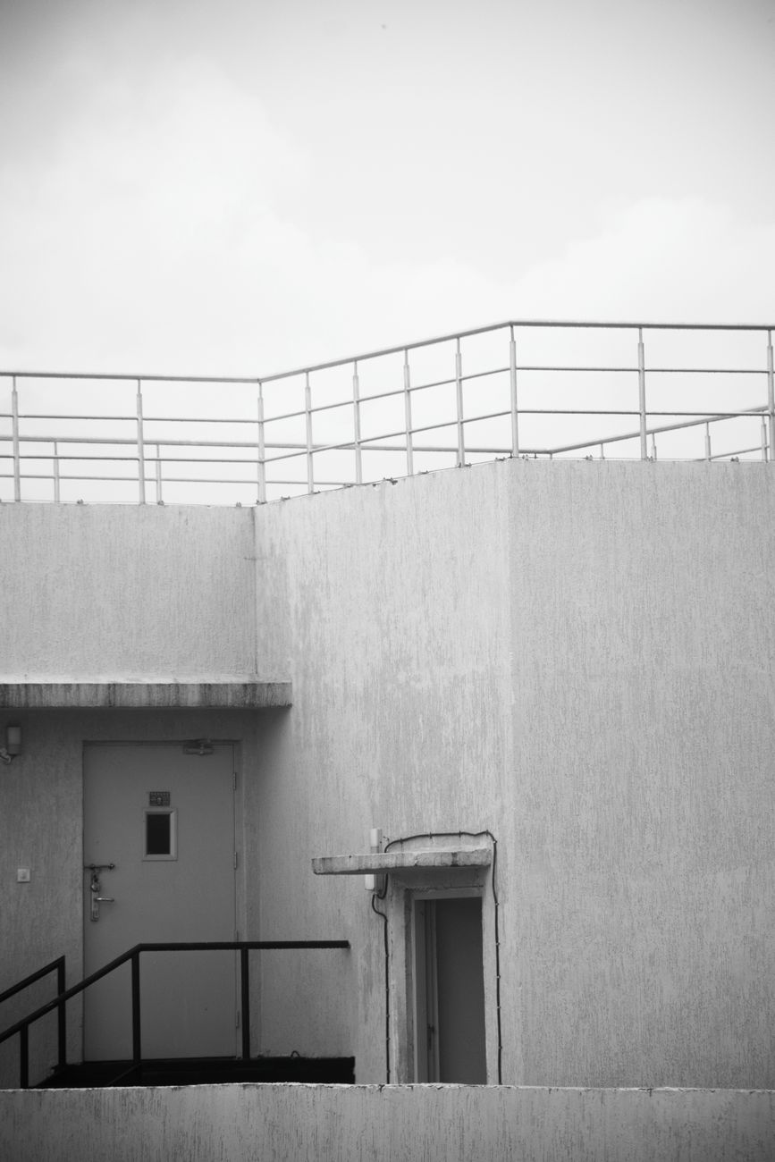 Monochrome photo of a minimalist concrete facade with sleek lines and geometric design.