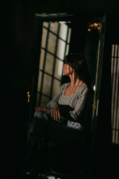 A woman sitting in a chair looking at a mirror